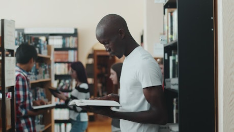 Man reading a book in a student library.