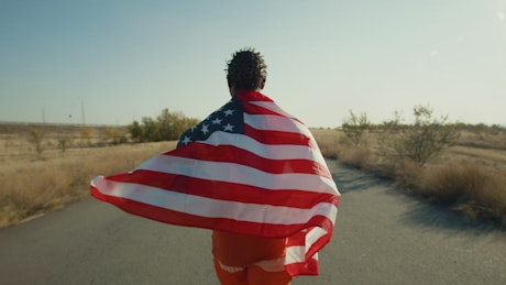 Man running along a path with the star-spangled banner around him.