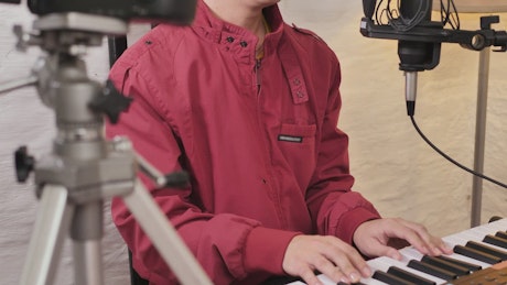 Man shooting a video singing and playing the piano.