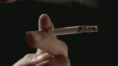 Man smoking a cigarette close up.