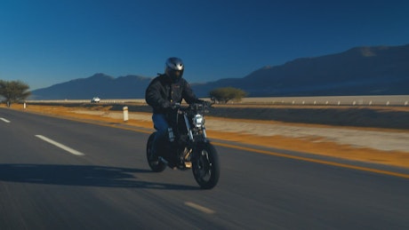 Man speeding a road on a motorcycle