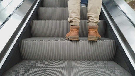 Man standing on an escalator.