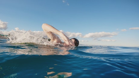 Man swims in the sea during the summer.