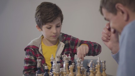 Man teaches young boy how to win at chess.