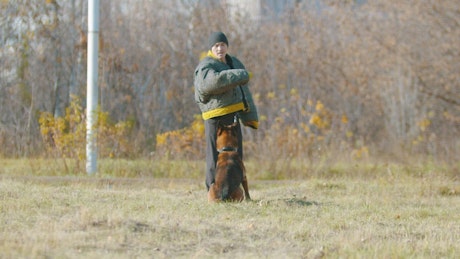 Man training a dog, outdoors.