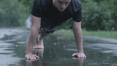 Man training outdoors while raining.