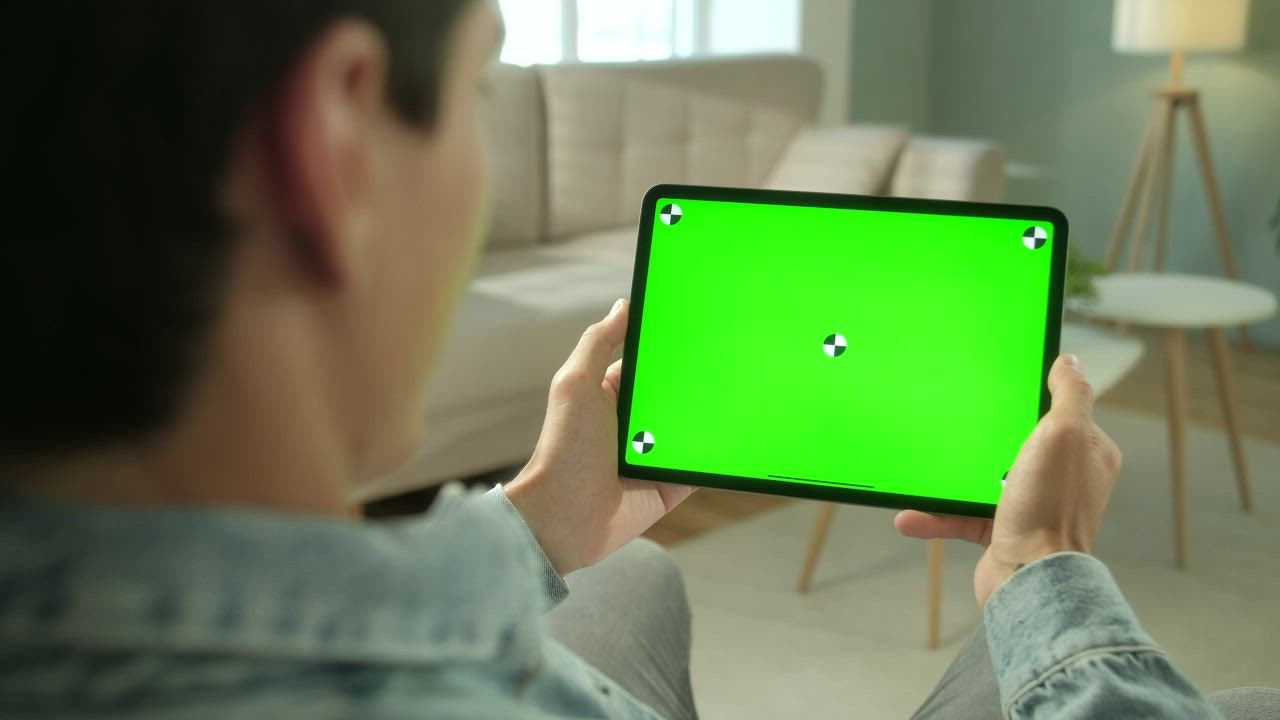 Man using green screen tablet in neutral living room - Free Stock Video