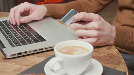 Man using online pay with credit card in cafe