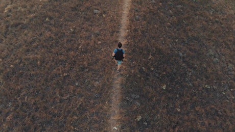 Man walking down a hill in an aerial shot.