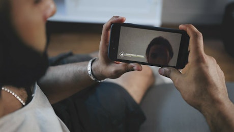 Man watches social media video on mobile screen