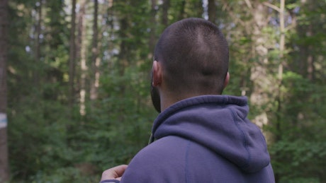 Man wearing headphones in woodland