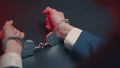 Man with handcuffs in the interrogation room.