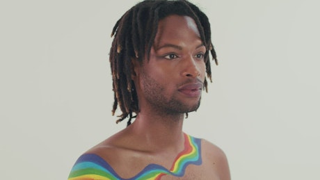 Man with the LBGTQ flag painted on his chest.