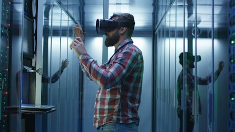 Man working with VR glasses in data center.