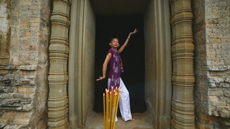 Mature Asian woman posing outside a Buddhist temple.