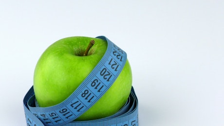 Measuring tape around an apple
