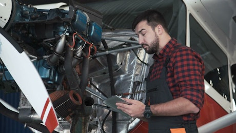 Mechanic inspecting an airplane engine