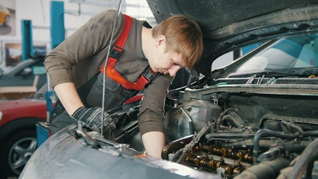 Mechanic working under the hood of a car.