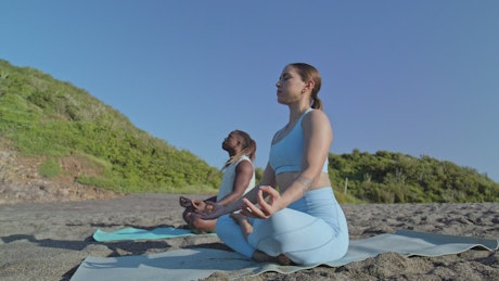 Meditation as a couple on a beach.