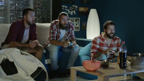 Men playing video games at home.