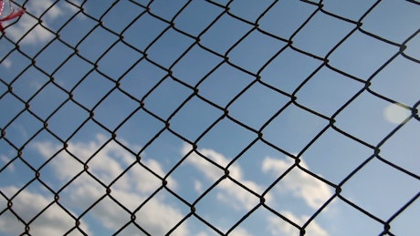 Metal mesh with blue sky in the background.