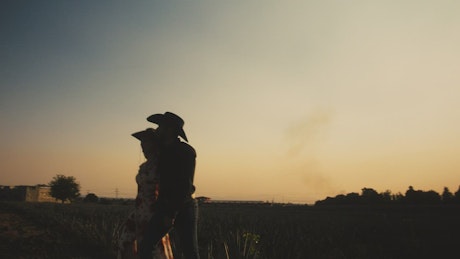 Mexican style man and woman on a ranch at sunset