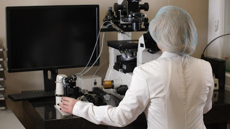 Microbiologist using a microscope.