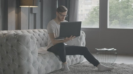 Millennial man working in minimalist living room