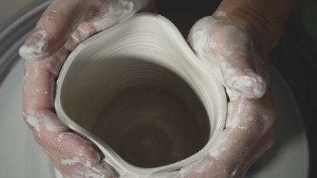 Potter moulding clay on pottery wheel