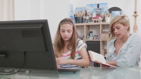 Mom helping girl learn computer skills