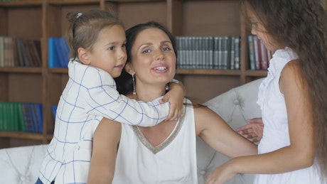 Mom hugs her two daughters