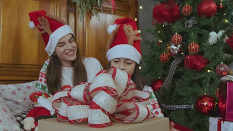 Mother and daughter opening a present at Christmas.