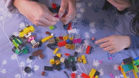 Mother and her daughter playing with Lego pieces.