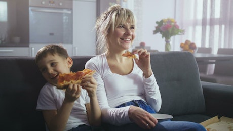 Mother and son eating pizza.