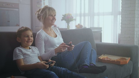 Mother and son playing video games together.