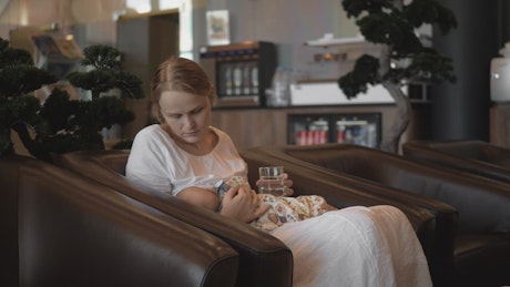 Mother breastfeeding her baby in a hotel.