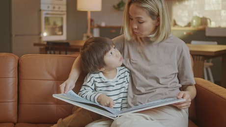 Mother reading her son a children's book.