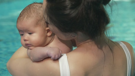 Mother with her little baby in a swimming pool.