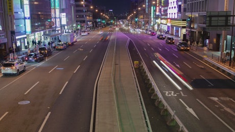 Motion on a Japanese avenue at night.