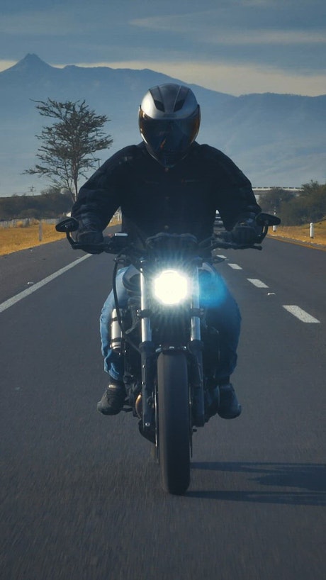 Motorcyclist going down a road seen from the front