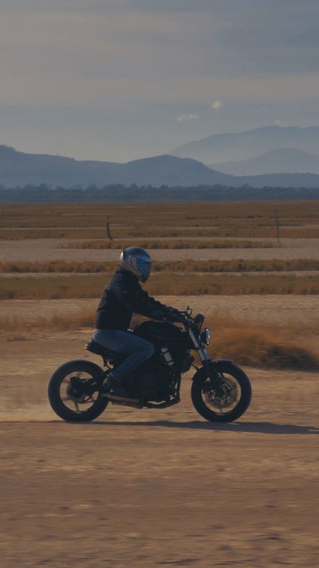 Motorcyclist speeding through a desert.