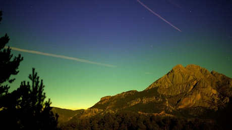 Mountain during a sunset and stars in the sky