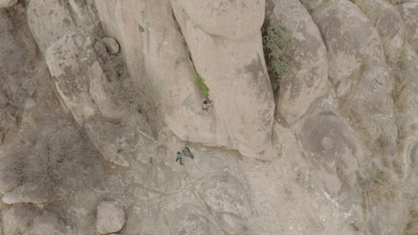 Mountaineer climbing a big rock.