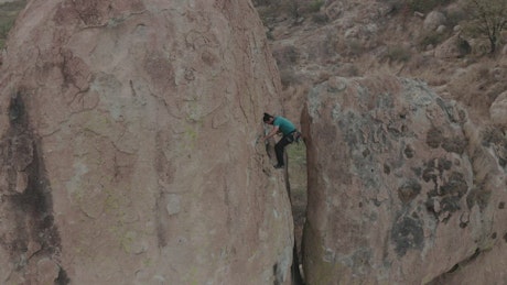 Mountaineer climbing a huge rock.