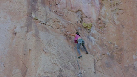 Mountaineer woman climbing a huge mountain.