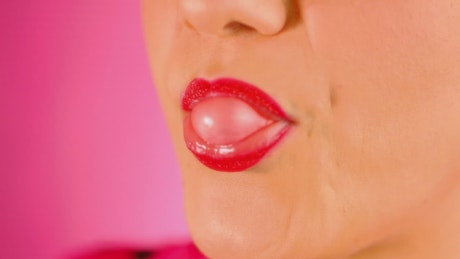Mouth of a woman making a bubble gum.