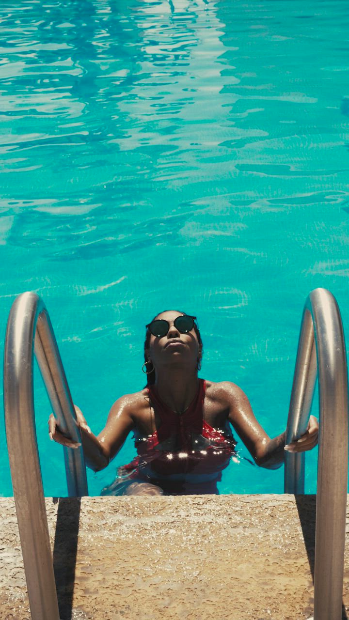Mujer en traje de baño saliendo de una piscina - Mixkit