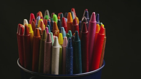 Multi color wax crayons on a black background.