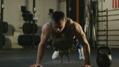 Muscular man doing push-ups in the gym.