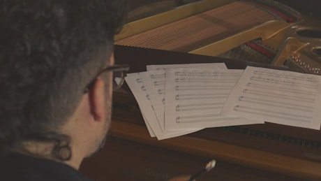 Musician composing a song on piano.
